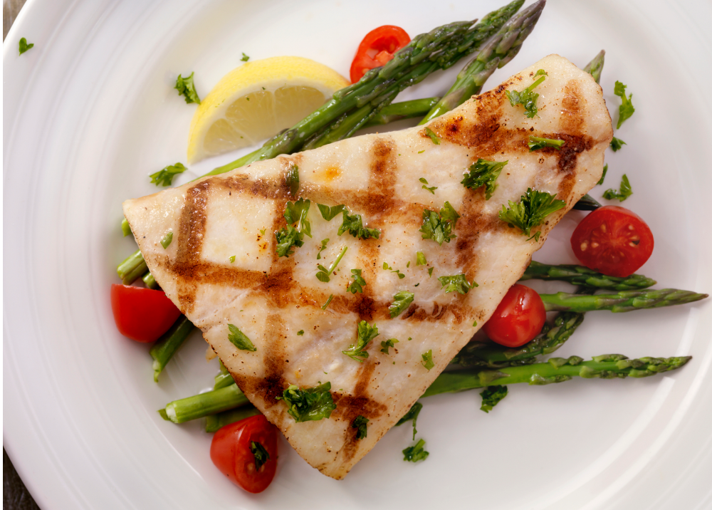 Grilled fish fillet with asparagus and cherry tomatoes.